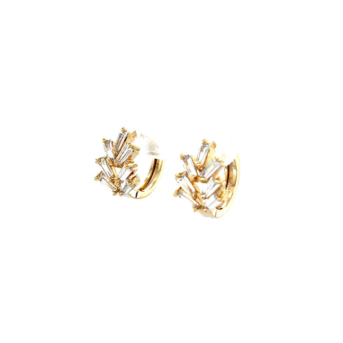 The Zirconia Stones Huggies earrings, crafted from 10k gold filled material, feature baguette-cut zirconia stones arranged in a starburst pattern. Set against a white background, they elegantly showcase their shiny design.